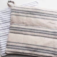 two DIY pot holders made with blue ticking stripe fabric
