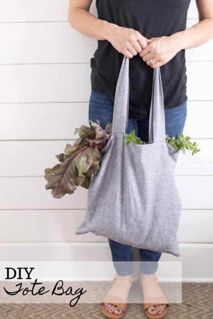 women wearing a black shirt and jeans holding a DIY tote bag full of lettuce