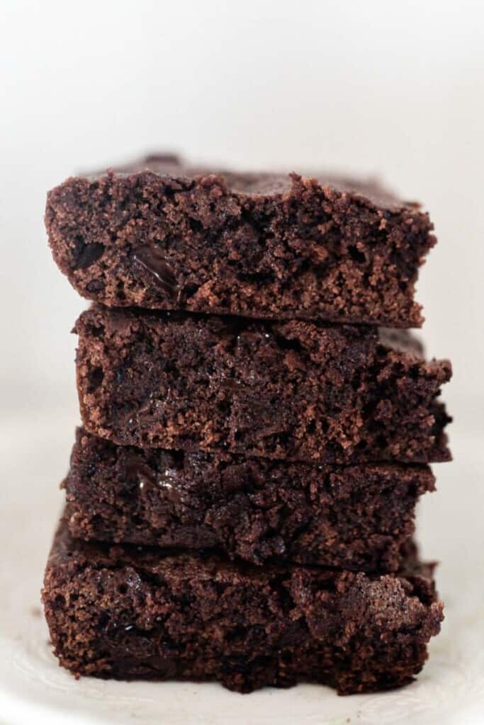 four einkorn brownies stacked on a white plate