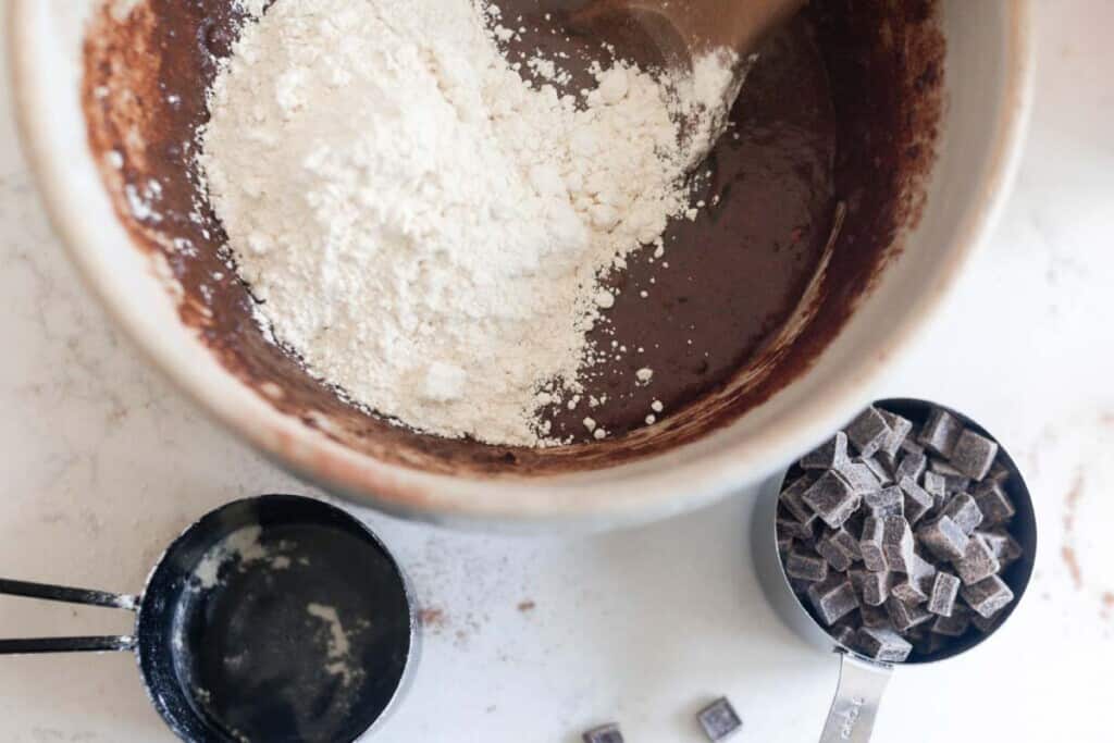 Einkorn flour being folded into the wet ingredients to make homemade brownies