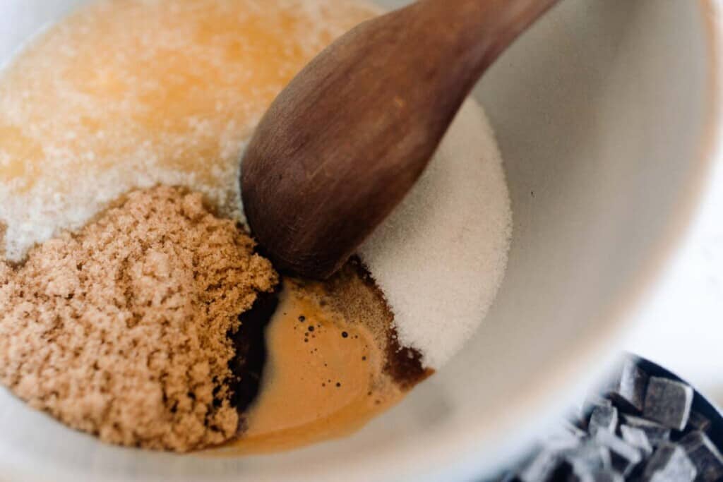 sugar, brown sugar, vanilla, espresso, salt, and cocoa powder in a large bowl with wooden spoon