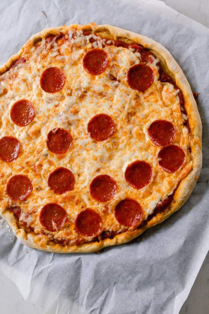 homemade pepperoni pizza fresh out of the oven on parchment paper