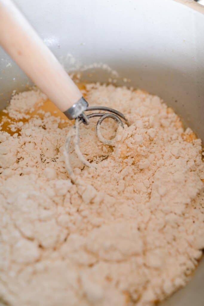 einkorn puff pancake ingredients in a large bowl with a whisk