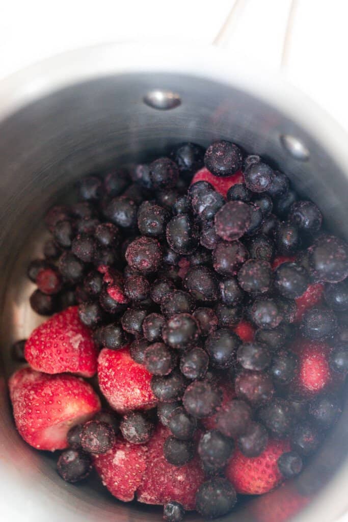 berries in a saucepan to make berry syrup