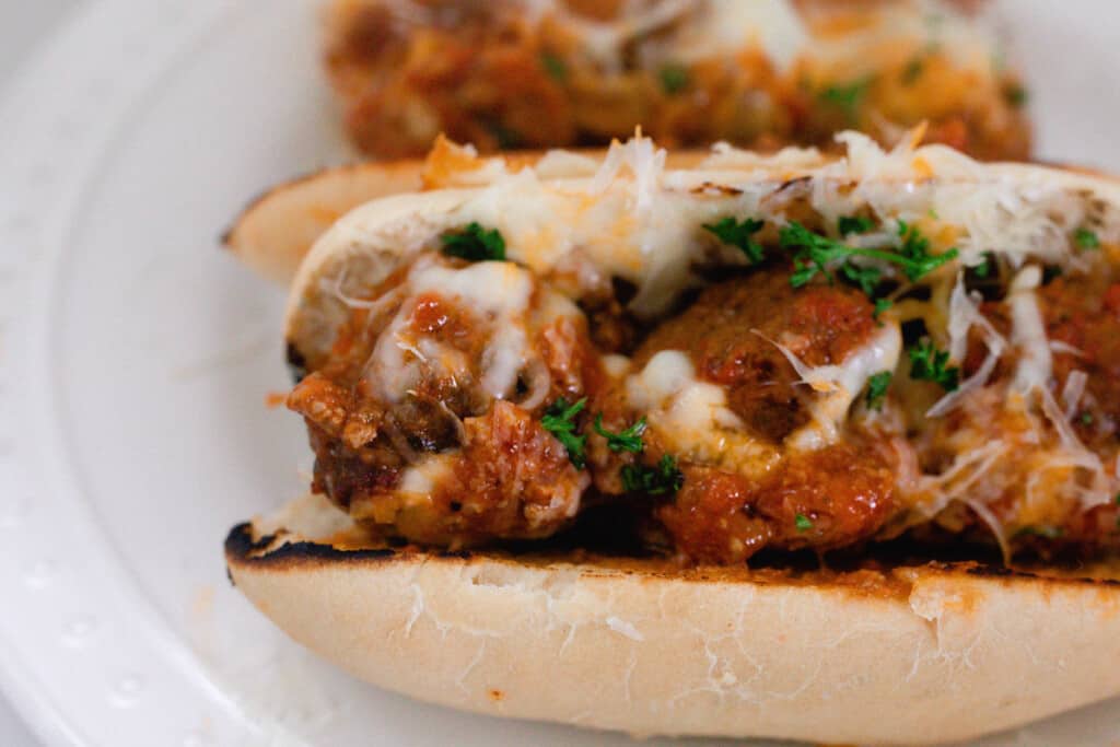 overhead photo of homemade meatball sub sandwich on a soft sourdough sandwich rolls.