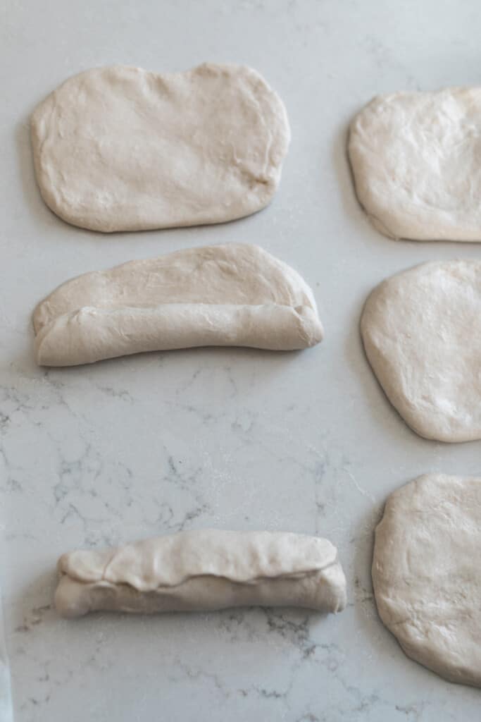 rolling up sourdough sandwich roll dough for baking