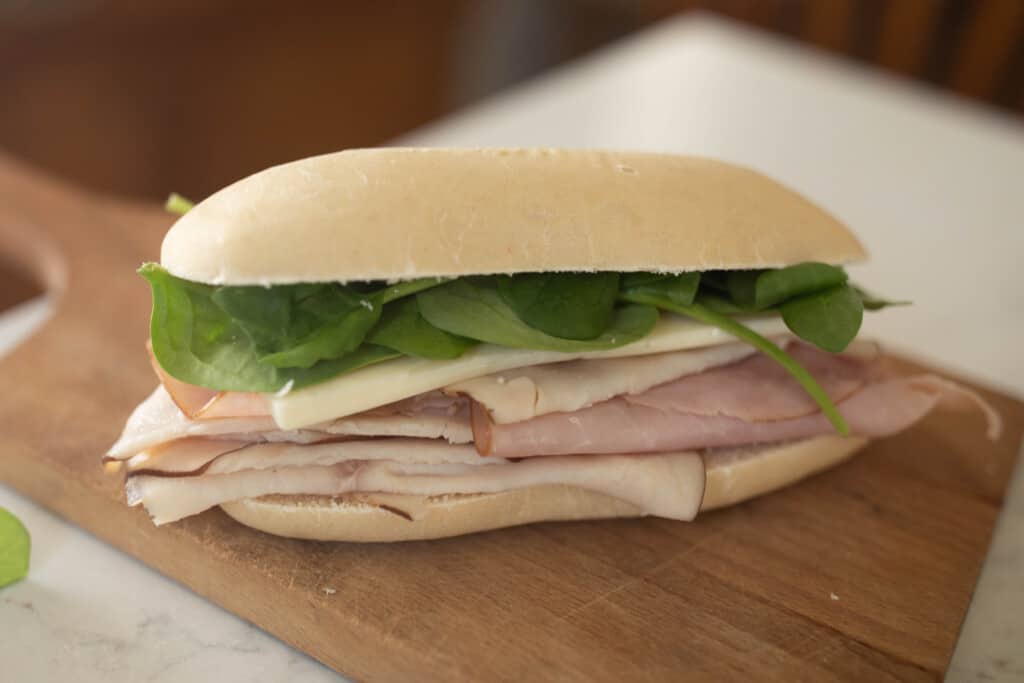 sourdough sandwhich with turkey, ham, cheese and spinach