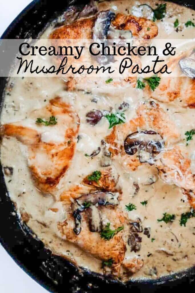 cast iron skillet with seared chicken breast and mushrooms in a cream sauce with fresh herbs on top