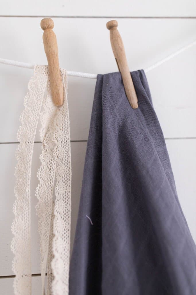 gauze fabric and lace hanging with a clothes pin against a shiplap wall