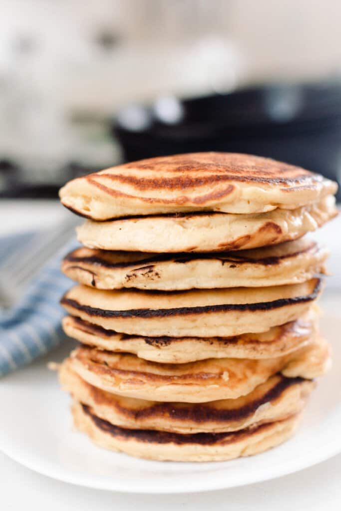 large stack of fluffy einkorn pancakes on a white plate 