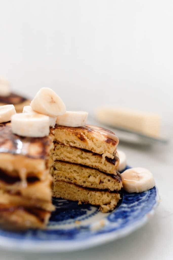 pancakes stacked four high and topped with bananas