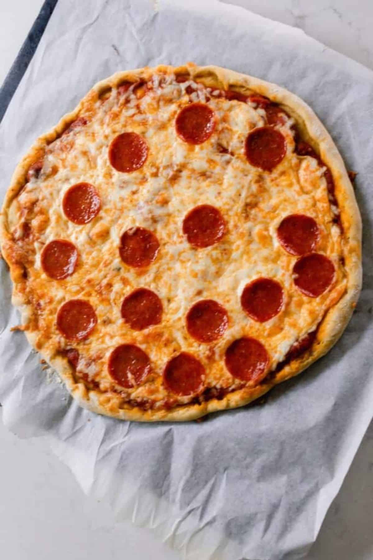 pepperoni pizza on an homemade einkorn crust on parchment paper.