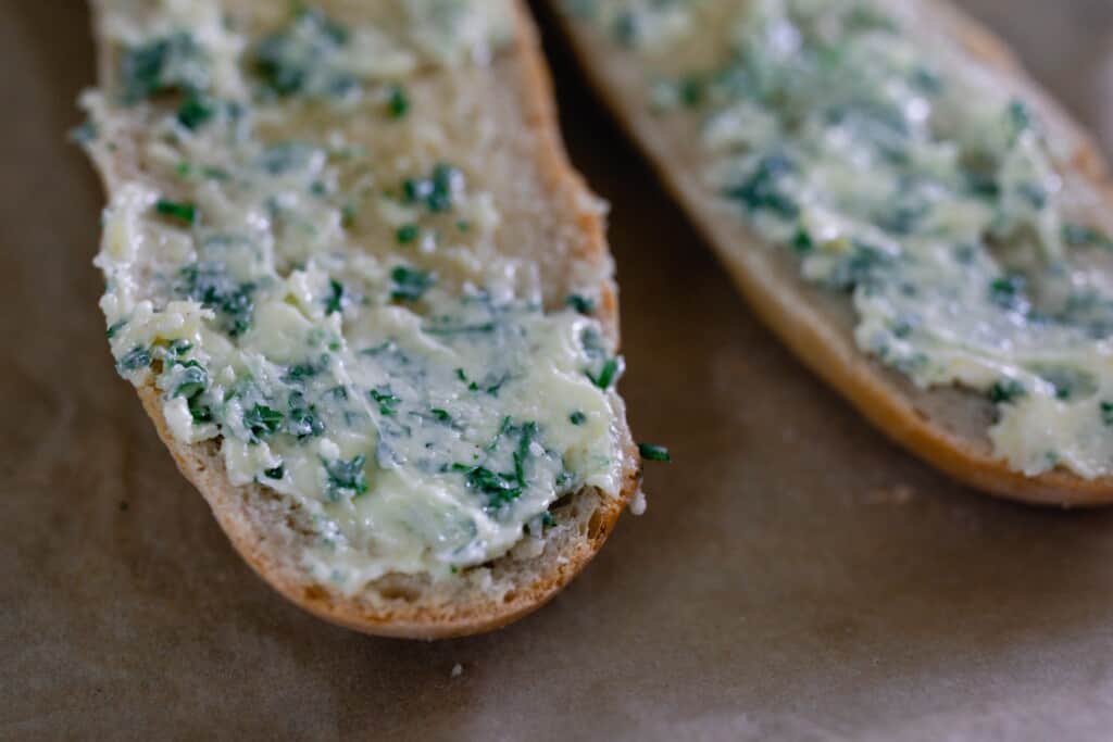 garlic butter with herbs smothered on sourdough baguettes