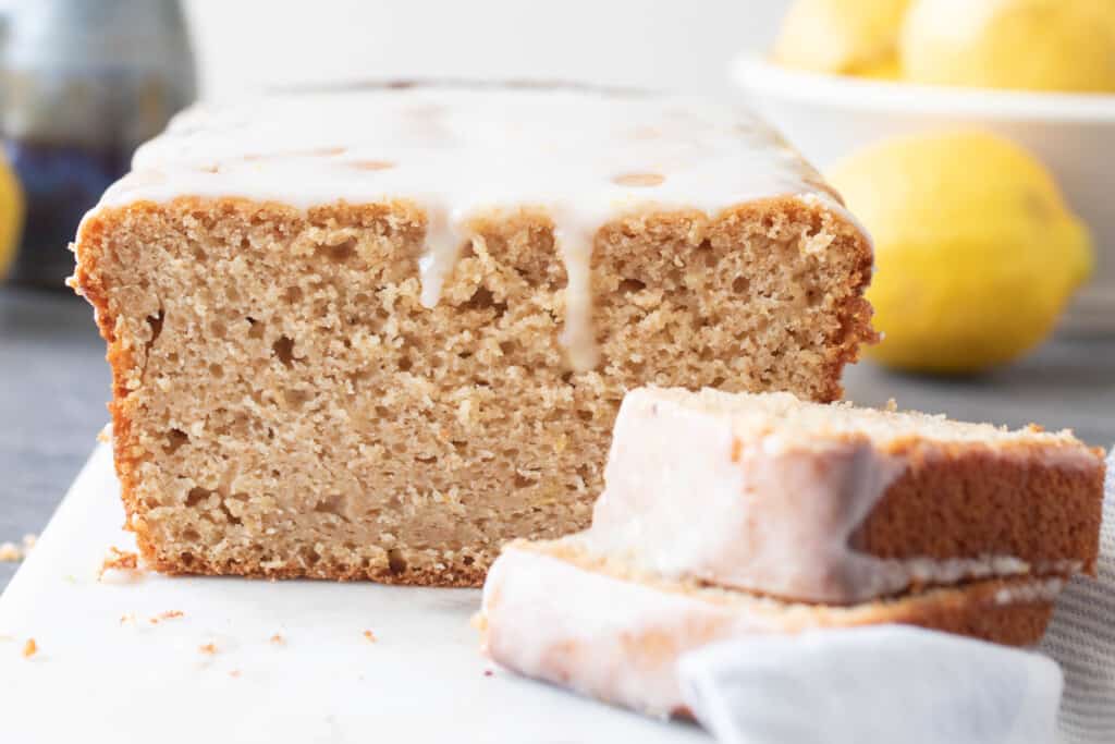 close up picture of lemon pound cake slice with the slices off centered on a marble serving tray