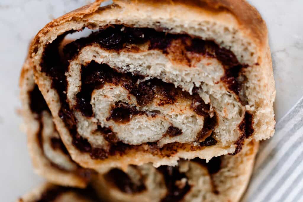 slice of sourdough cinnamon raisin bread with a cinnamon raisin swirl on a stripped towel