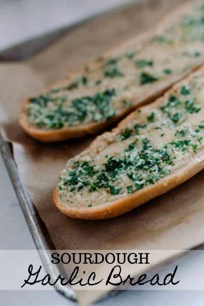 sourdough French bread cut in half and covered with garlic butter baked in the oven on parchment lined baking sheets