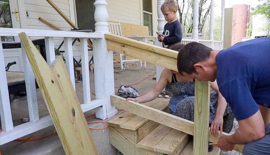 man and women adding a second bottom rail to a hand rail for support