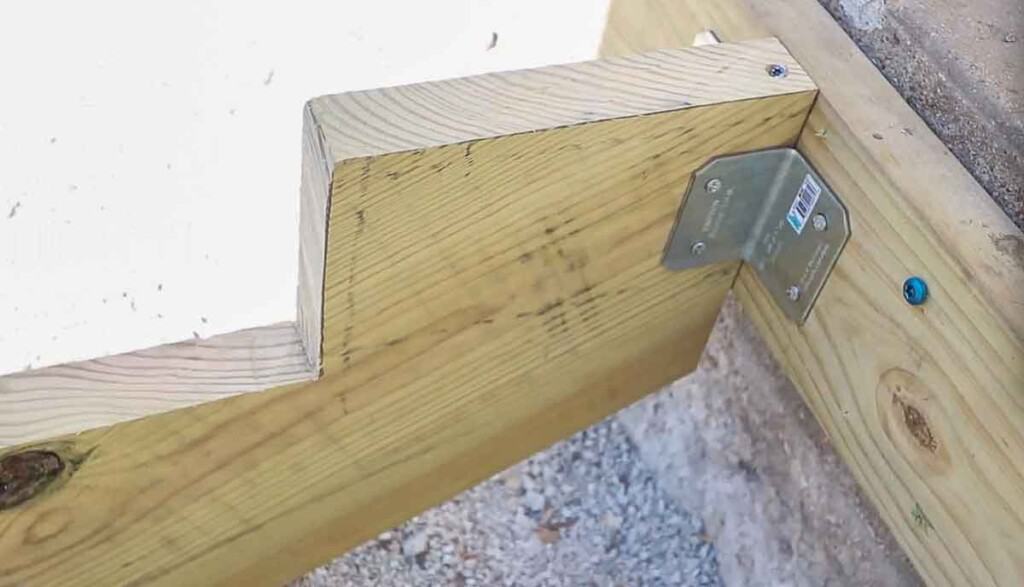 stair stringers attaching to the anchor board using metal brackets and screws