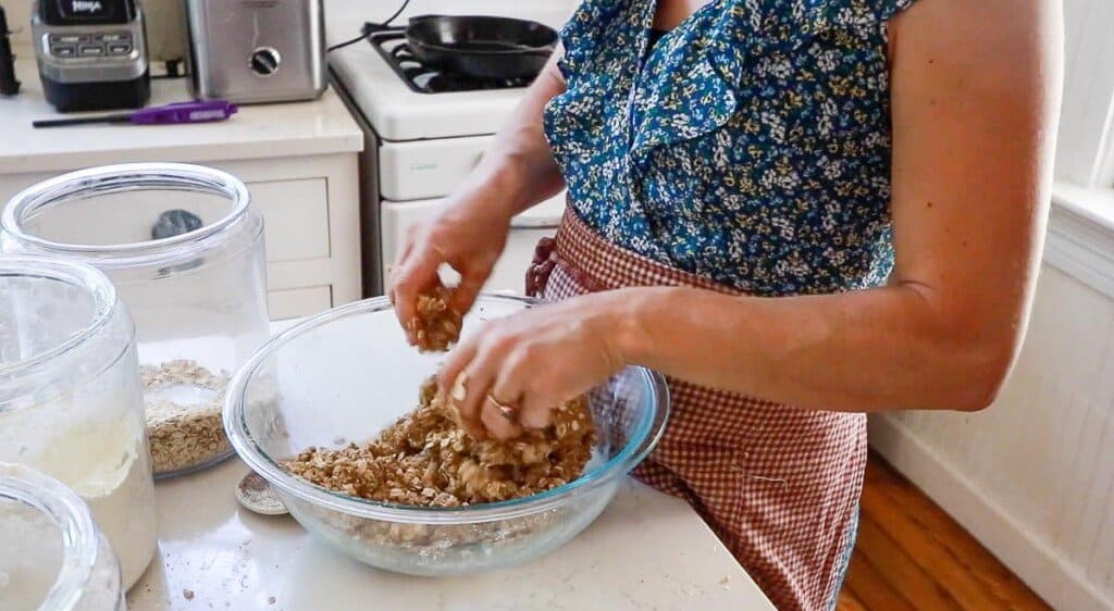 women wearing a red apron cutting in butter with her hands