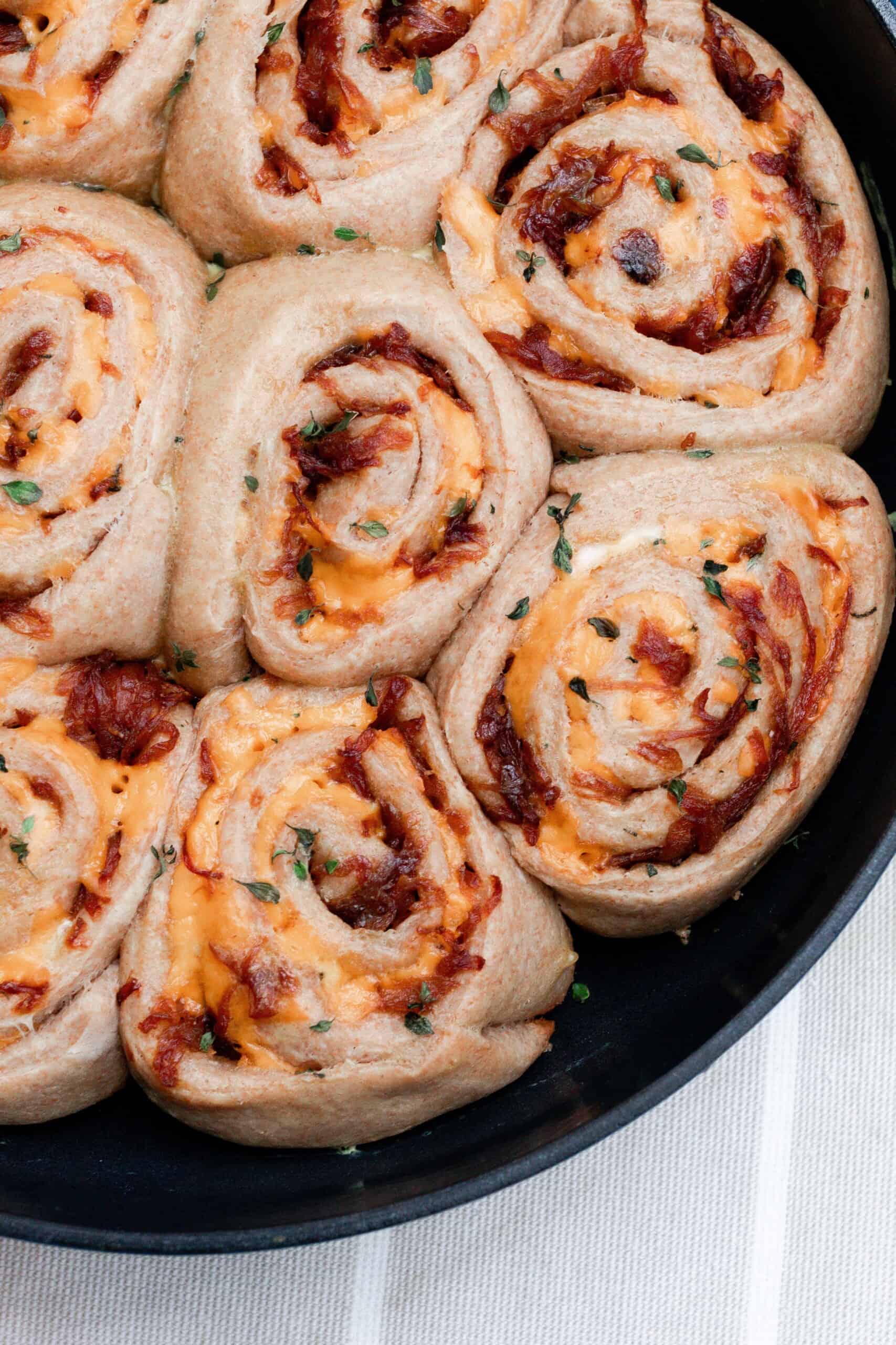 overhead photo of sourdough herb and cheese rolls with caramelized onions.
