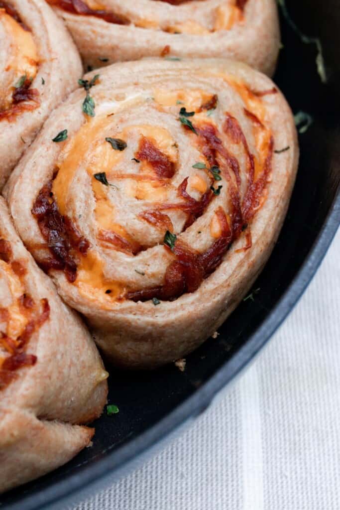 close up of herb and cheese rolls in a cast iron dish