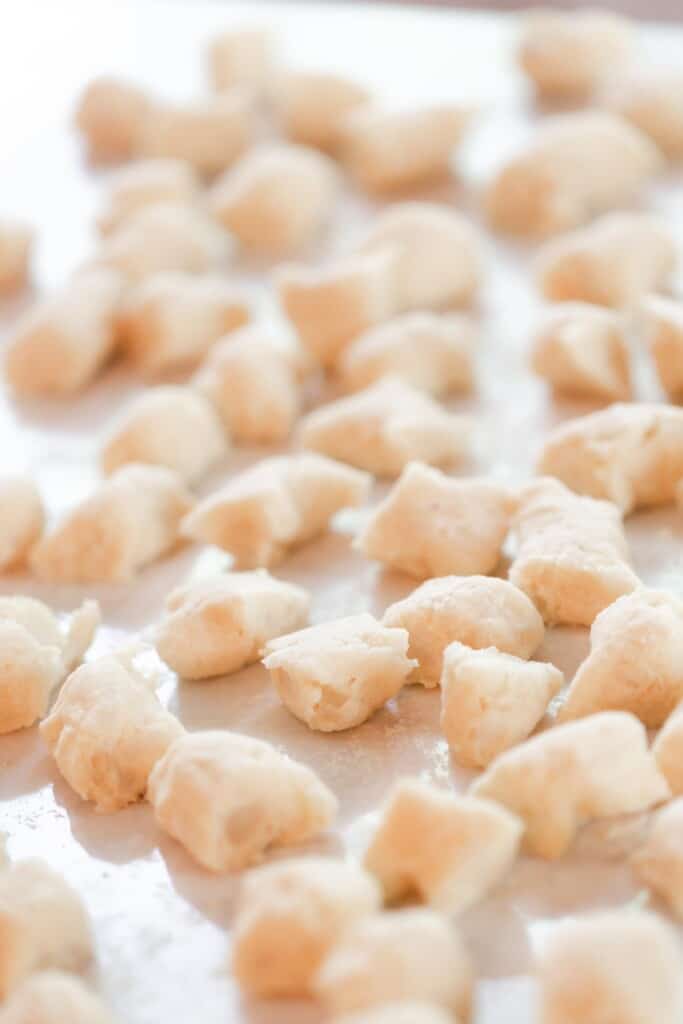 homemade gnocchi sliced into squares on a white quarts countertop