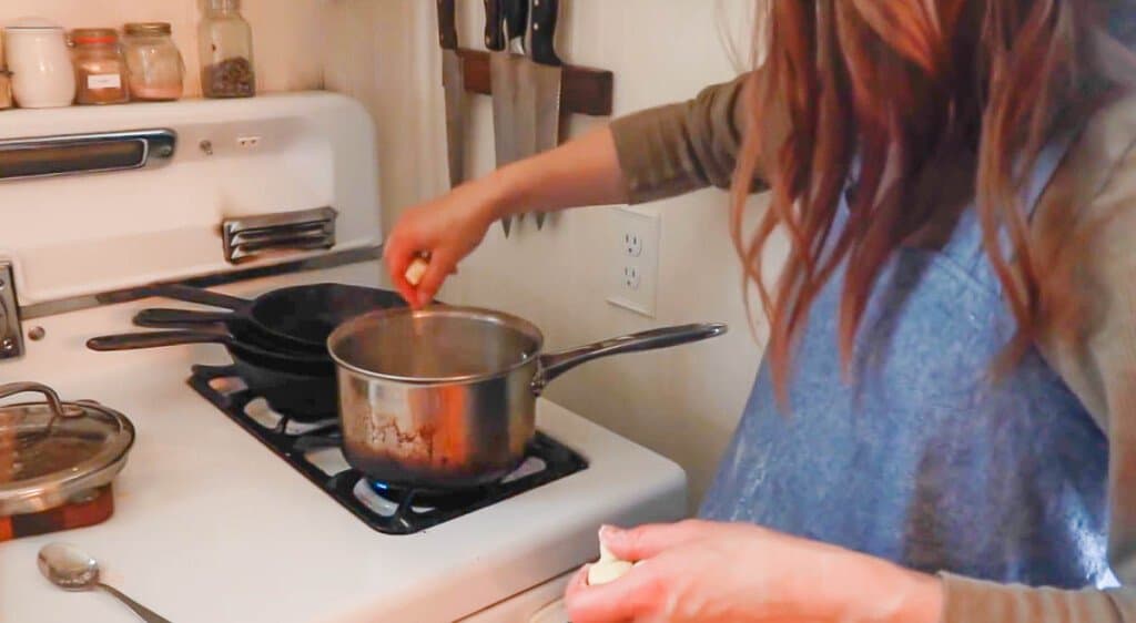 women adding homemade gnocchi to a pot with boiling water