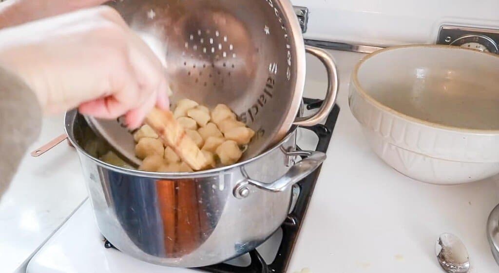 adding homemade gnocchi to soup in a large pot