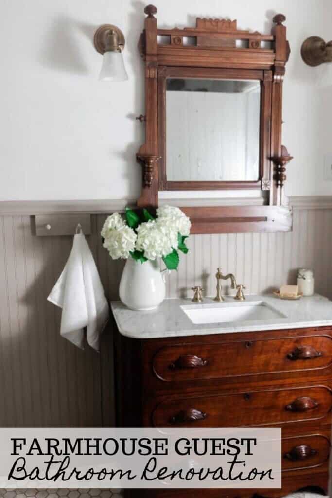 Antique dresser turned into a vanity with a marble tub with a ornate wood mirror. Bead board graces the walls and antique accessories