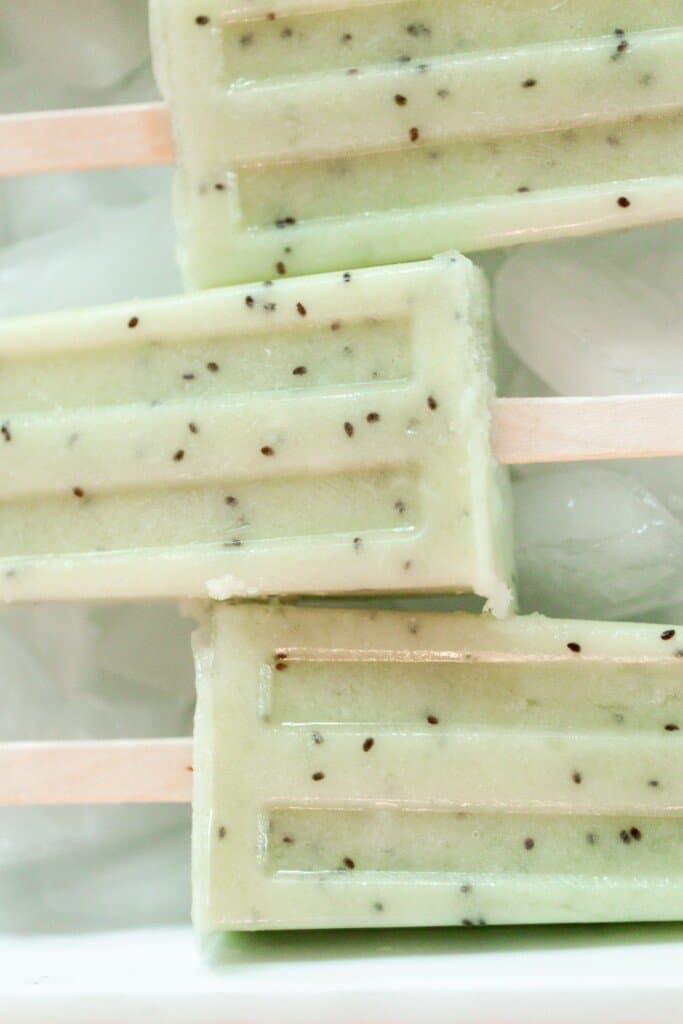 three green lime popsicles with kiwi on a layer of ice