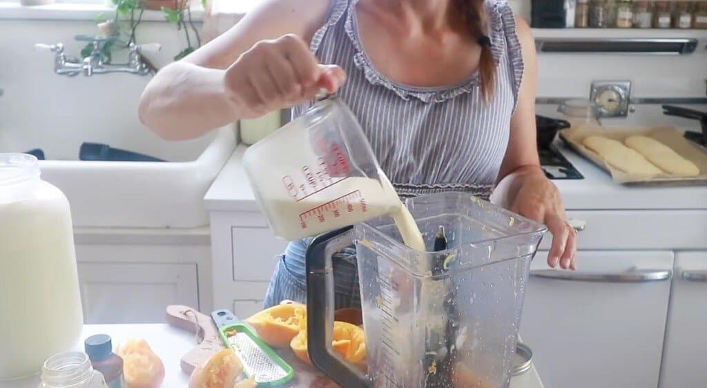 women pouring milk and cream into a blender to make popsicles