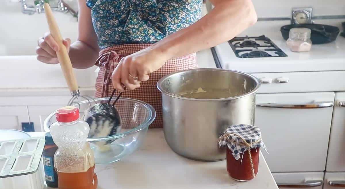 Woman mixing yogurt in a glass bowl.