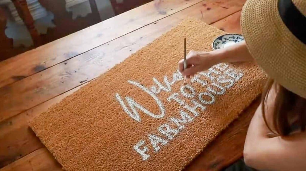 women using a paintbrush to pain on a brown mat