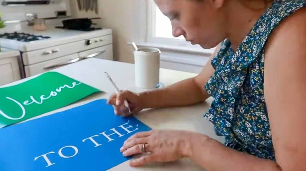 women removing vinyl letters from cut vinyl