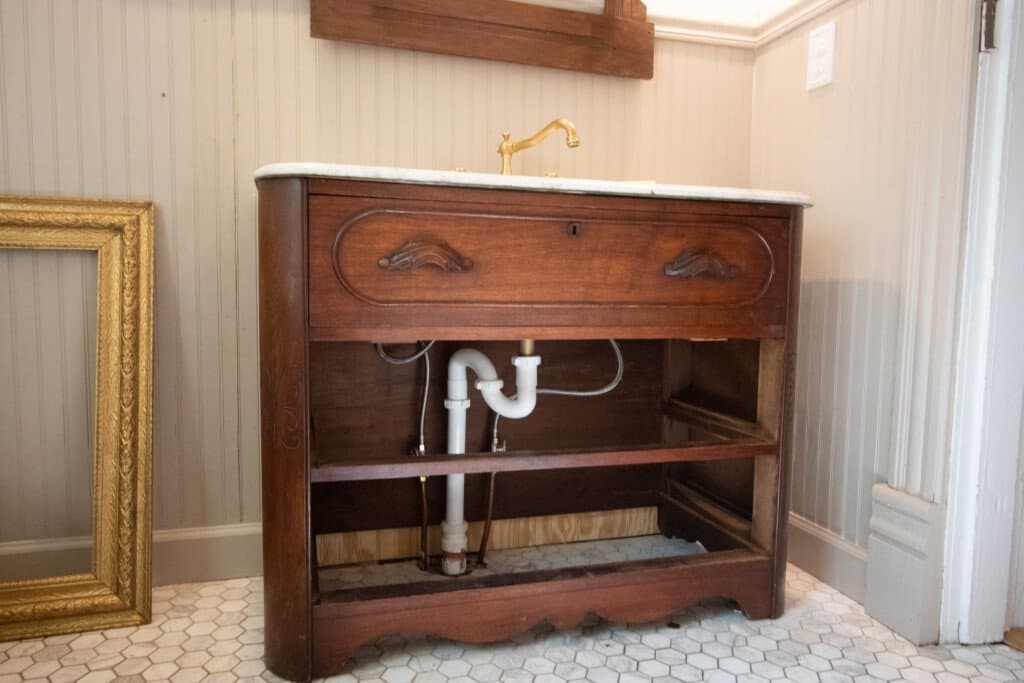 wooden dresser with marble top plumbed in to turn into vanity. Two bottom drawers are removed