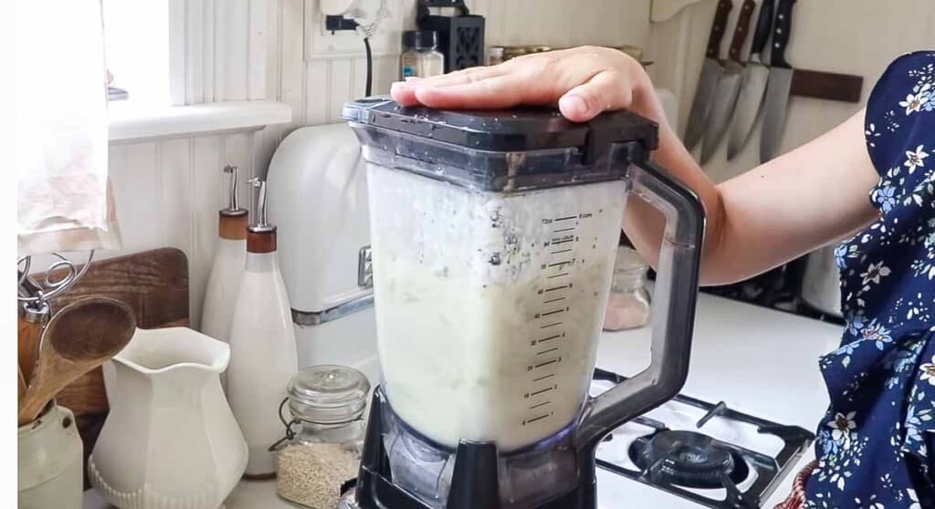 blender blending honey, yogurt, lime juice and kiwi together to make popsicles