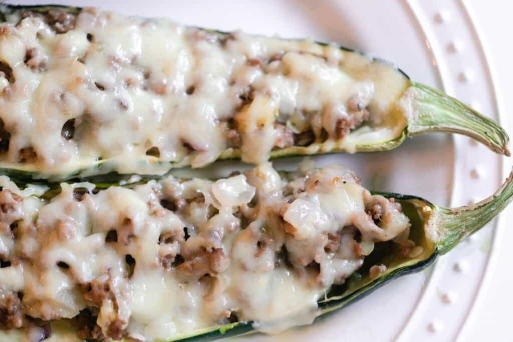 two halves of zucchini boats with sausage and cheese