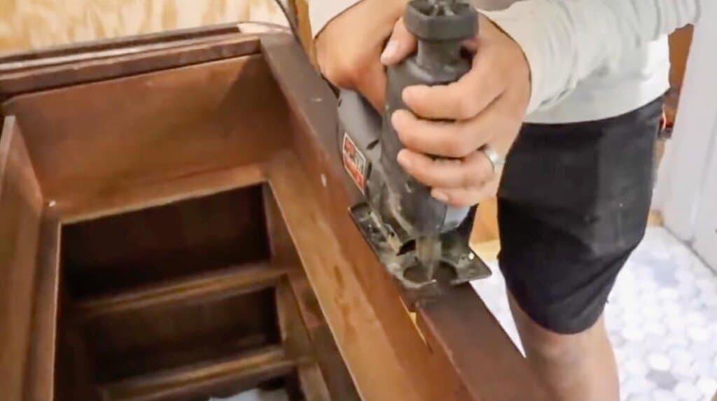 jigsaw cutting out a notch out of a dresser to accommodate a sink