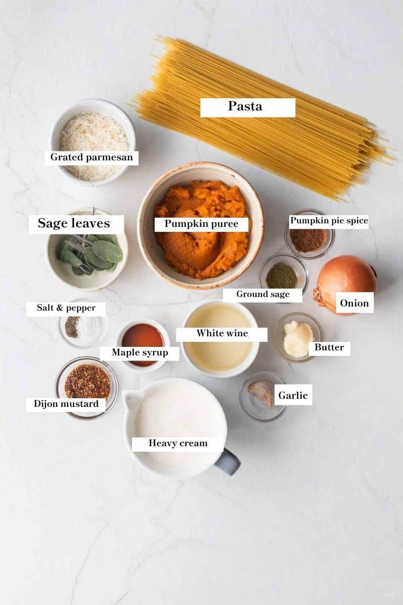 Ingredients for pumpkin pasta sauce in white dishes on a white counter top.
