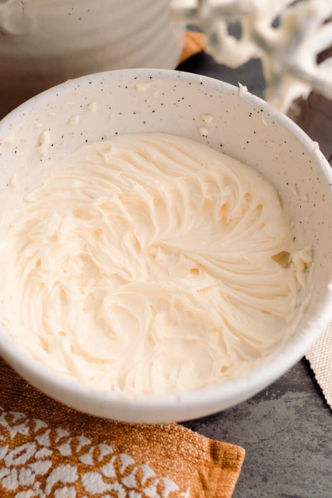 butter and sugar whipped in a bowl  with a orange  napkin in the front of the bowl