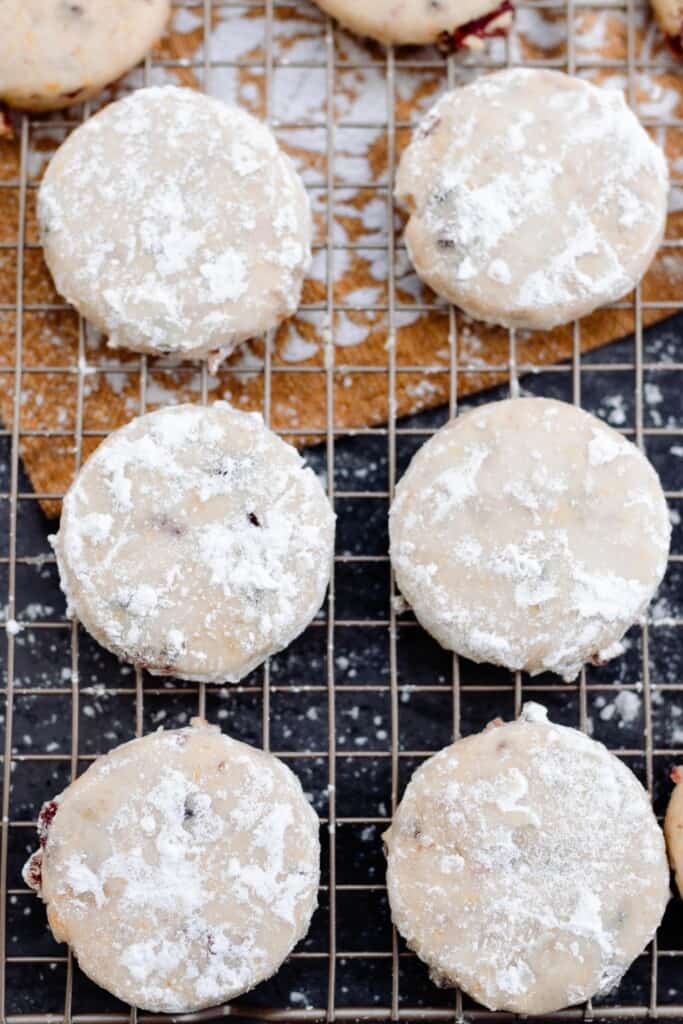 cranberry orange cookies on a wire rack and dusted powdered sugar