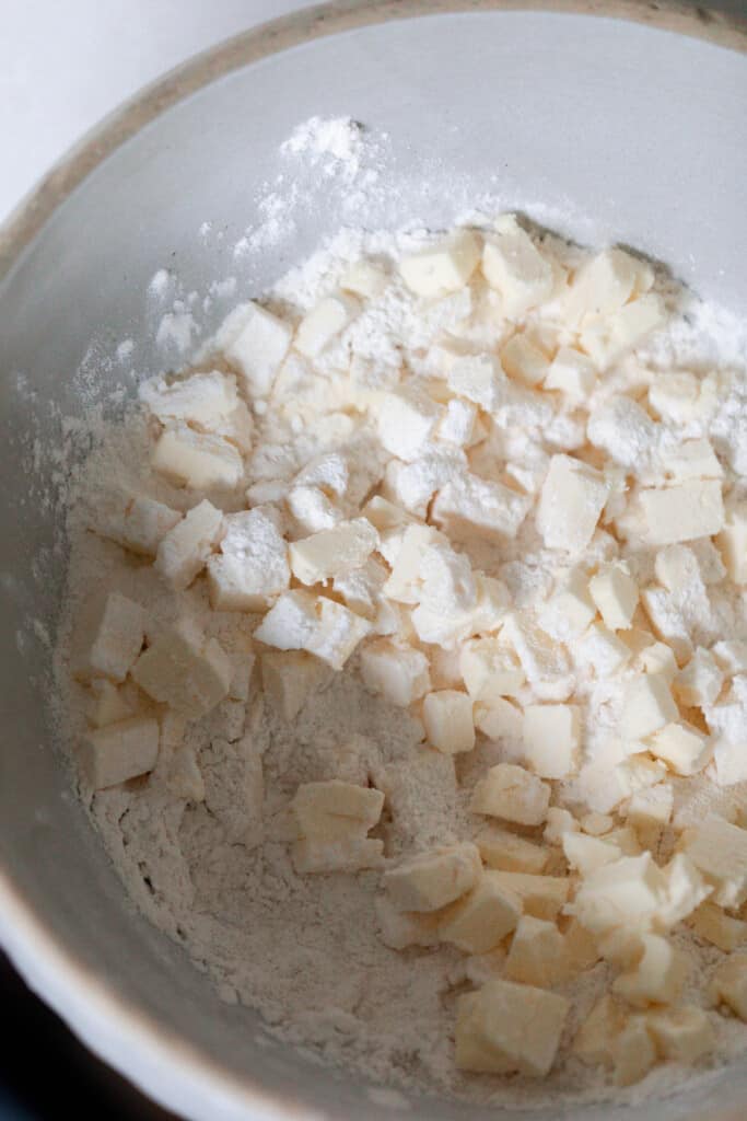 butter chopped in and added to flour in a cream colored bowl 