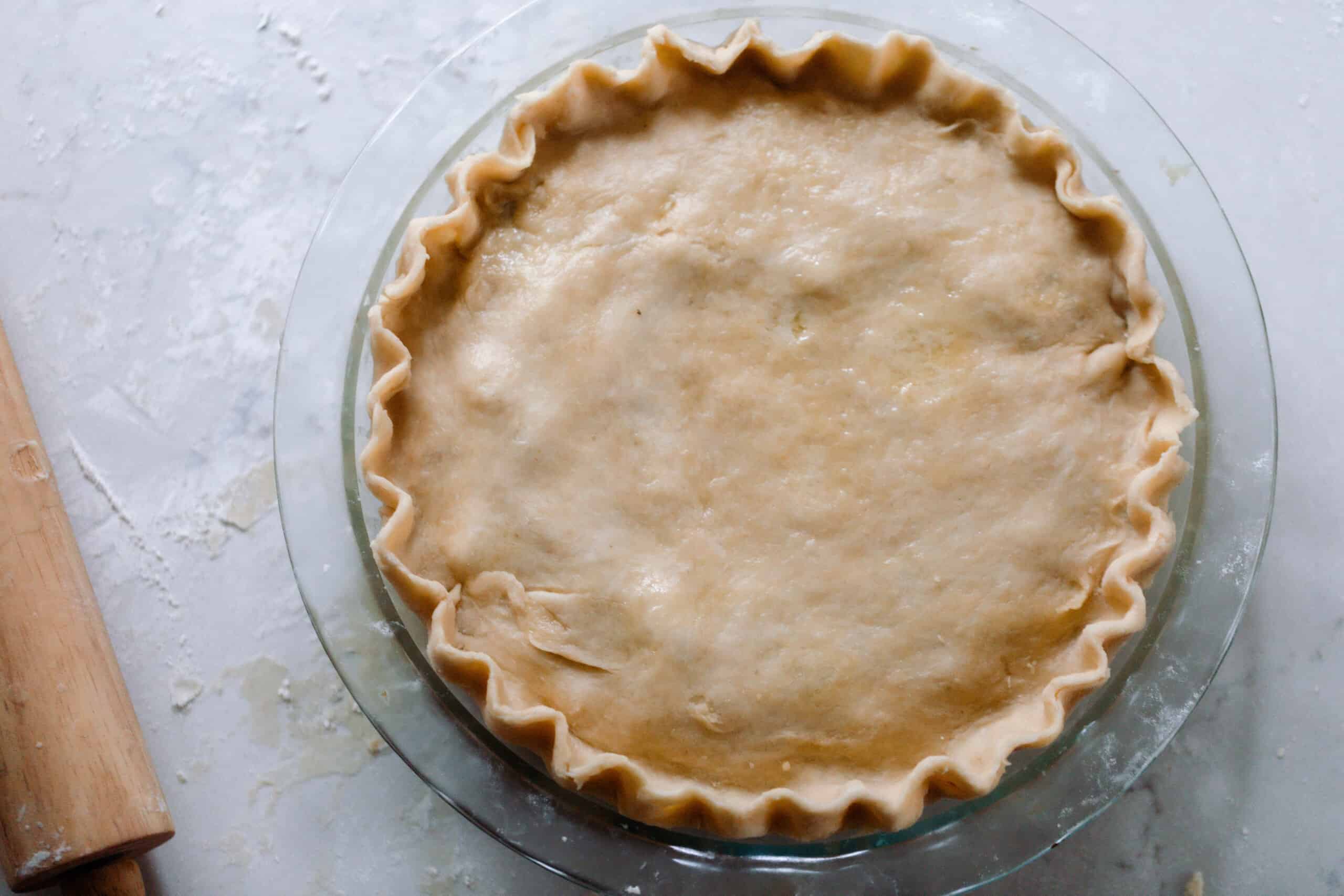 overhead photo of einkorn pie crust made into a pie on a white quartz countertop