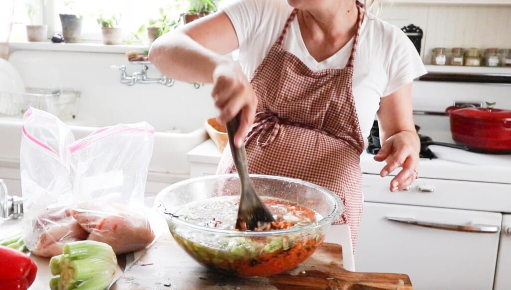 stirring chicken and wild rice soup in a glass bowl