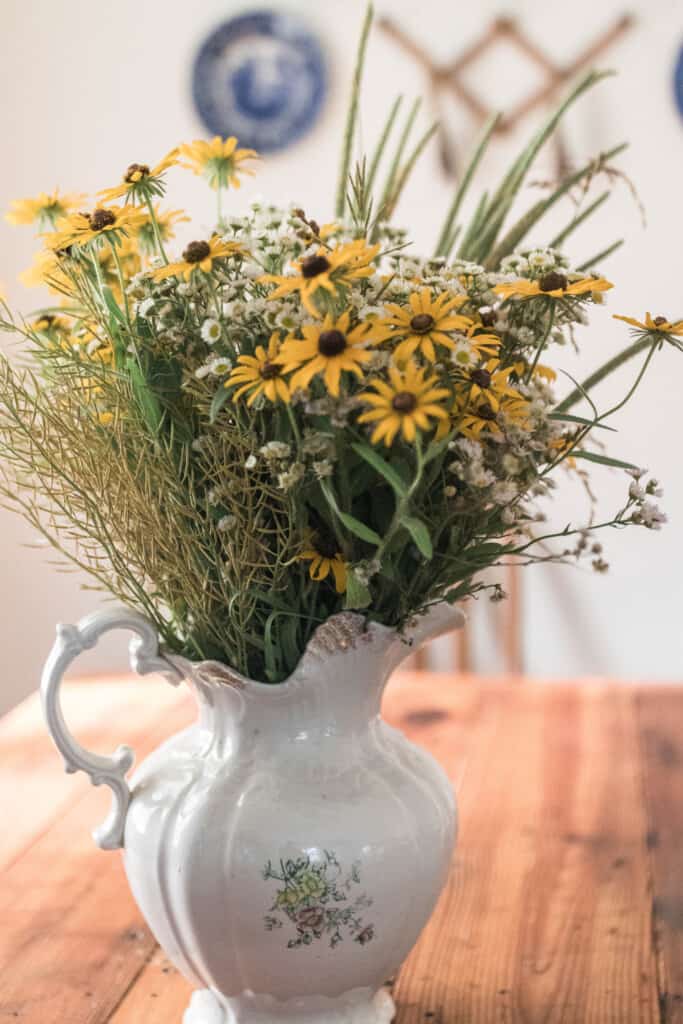 Wildflowers in a vintage pitcher on a wooden table