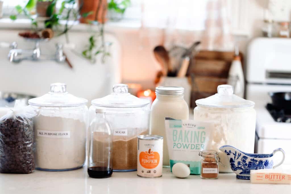 pumpkin sourdough scones ingredients lined up on a white quarts countertop with a antique sink in the background