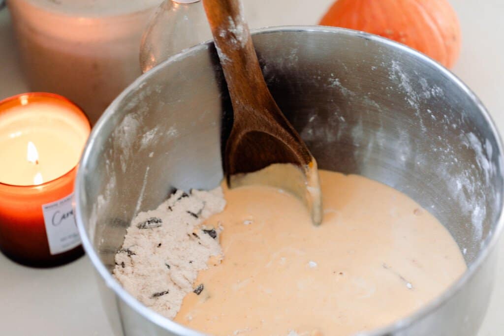 a metal bowl with the wet ingredients added to the dry ingredients to make pumpkin scones