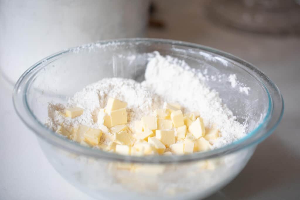 chopped butter and flour in a glass bowl 