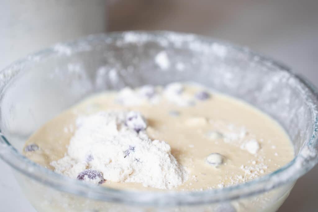 wet ingredients added to dry ingredients in a glass bowl