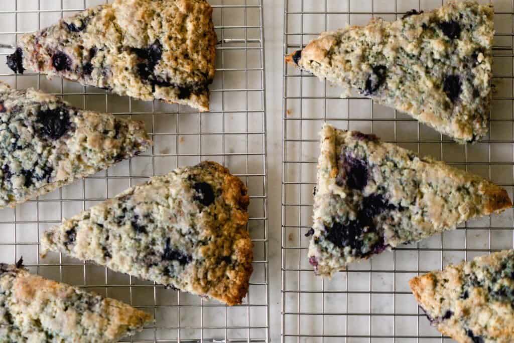 seven blueberry sourdough scones cooling on a wire rack on a wire rack
